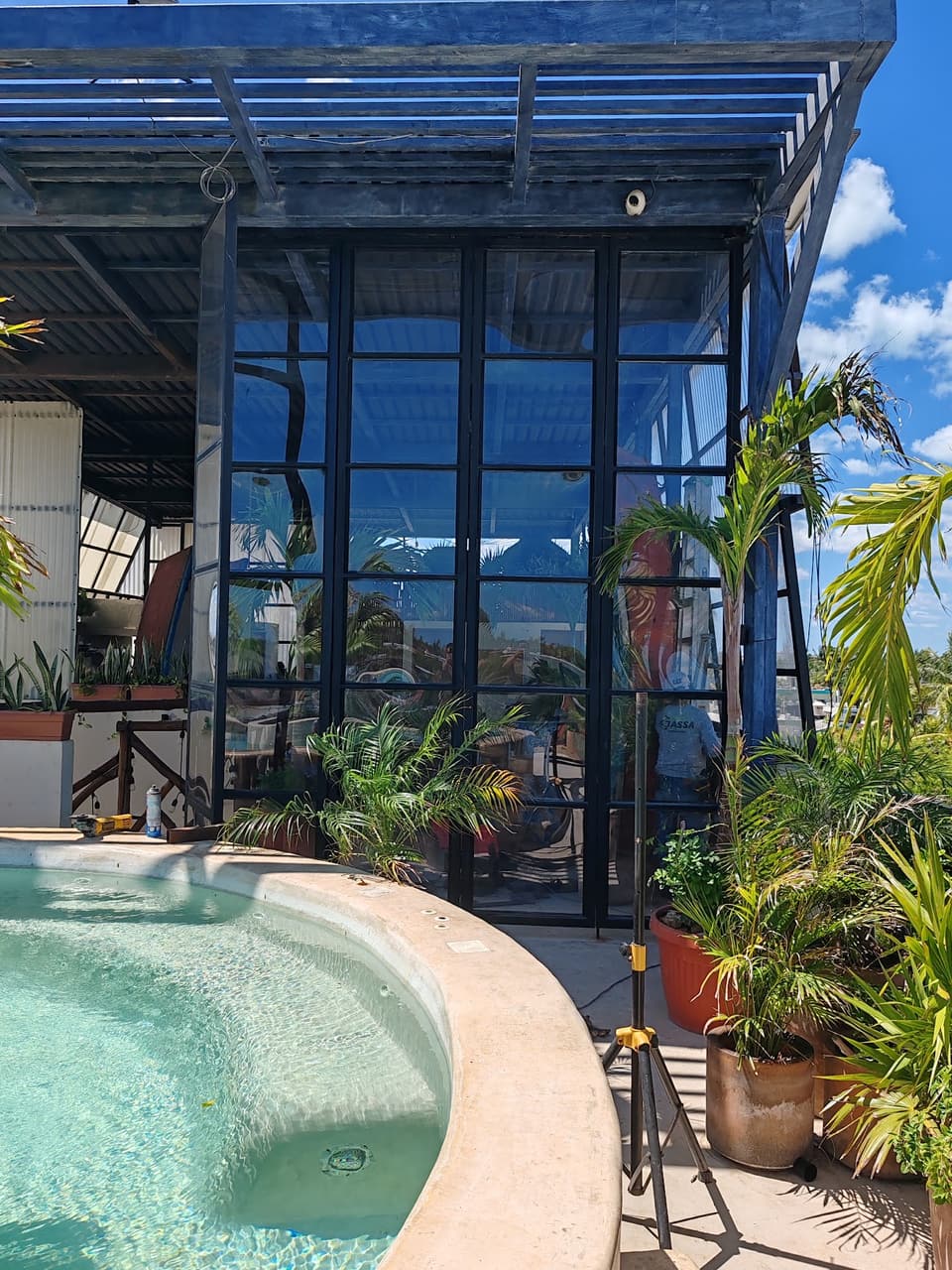 Fachada de acero y vidrio frente a alberca en Holbox