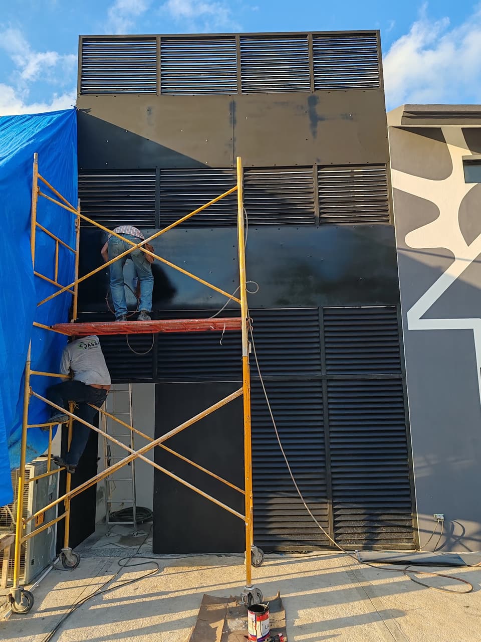 Montaje de fachada con celosía metálica en edificio comercial