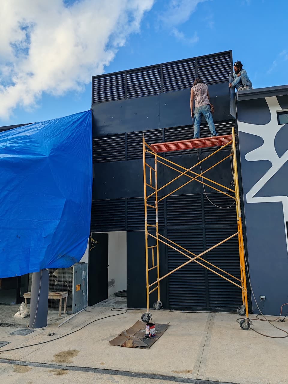 Instalación de celosía metálica en fachada con andamios