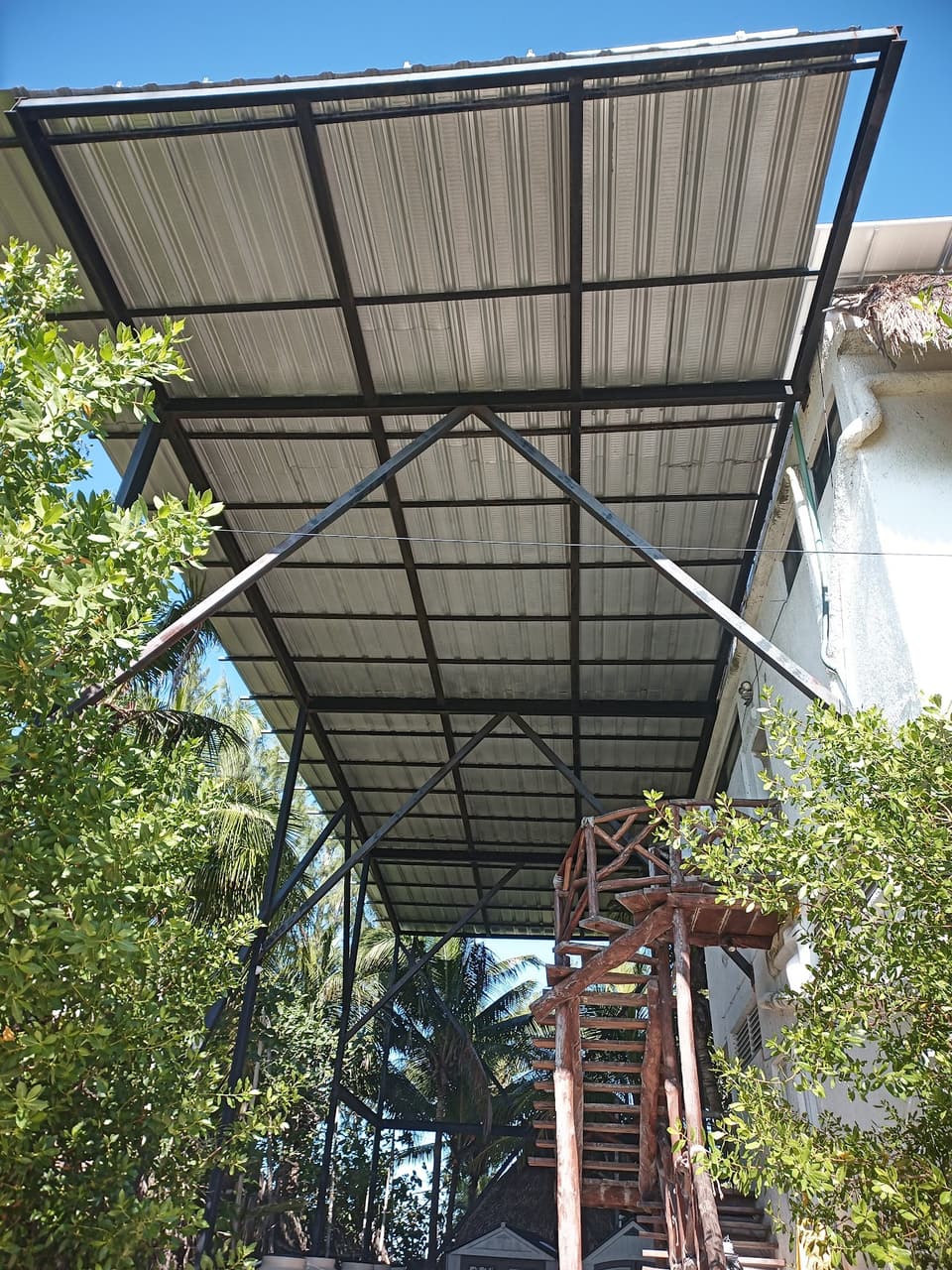 Pérgola de acero con cubierta de lámina en jardín